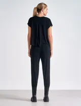 Enterito negro de modal y poliéster, con mangas cortas, escote redondo, laterales abiertos, cintura elastizada y bolsillos laterales. El pantalón es estilo jogger con terminación ajustada en el ruedo.