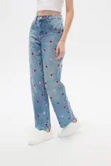 Pantalón jean de tiro alto y corte recto, color azul claro, con bordados de pequeños corazones rojos y rosados en toda la prenda.