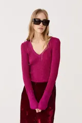 Top fucsia de lurex con escote en V, manga larga y tejido tipo rib.