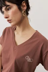 Remera de manga corta color negro, de corte clásico y escote en V, con sutil detalle bordado en el pecho.