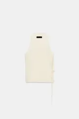 Chaleco color crema, sin mangas, con escote pico cruzado y lazada lateral.