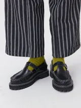 Zapato tipo guillermina de cuero color bordó, con diseño de mocasín, hebilla metálica y suela de goma con plataforma dentada.