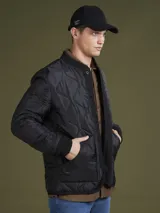 Campera acolchada verde militar con cuello mao, cierre frontal con botones a presión y bolsillos laterales.