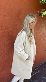 Tapado de corte oversize confeccionado en mezcla de lana y viscosa, color crema. Presenta un diseño desestructurado, liviano, con solapas amplias, bolsillos frontales de parche y mangas largas con puños vueltos.