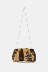 Bolso tipo pouch confeccionado completamente con cuentas de madera en tonos marrón, beige y tostado, formando un patrón abstracto. Cuenta con una correa fina de cadena dorada desmontable y cierre superior con cremallera.