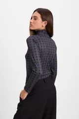 Polera de cuello alto y manga larga con estampado geométrico de rombos en tonos bordó y detalles en blanco.