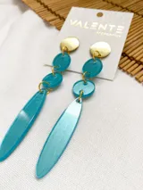 Aros colgantes con base dorada y dijes de acrílico turquesa en forma de óvalos y lágrima.