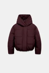 Campera tipo puffer acolchada color bordó, con cuello envolvente, capucha integrada, cierre frontal con botones a presión ocultos por solapa y bajo con elástico.