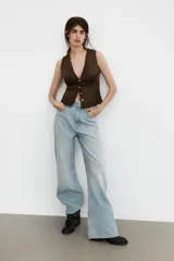 Jeans de tiro alto con diseño de pierna extra ancha y larga. Presenta cinco bolsillos, cierre frontal con cremallera y botón metálico, con un acabado de lavado desgastado.