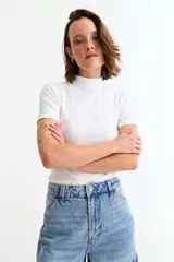 Remera de manga corta con cuello media polera, confeccionada en tejido de punto acanalado al cuerpo.