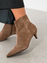 Bota corta de cuero con punta fina y taco fino de 5 cm, diseño minimalista y elegante.