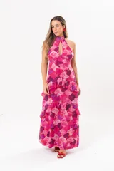 Vestido largo fucsia con estampado abstracto, cuello halter con abertura en forma de lágrima y volados en la falda.