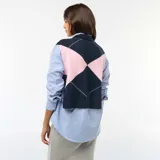 Sweater sin mangas de punto con diseño de rombos en azul marino y rosado. Presenta cuello redondo y aberturas laterales ajustables con lazos.