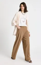 Pantalón sastrero de tiro alto en color camel, con corte recto y pernera ancha. Presenta pliegues frontales, bolsillos laterales y cierre frontal con cremallera y gancho. Incluye un cinturón a juego con hebilla metálica ovalada.