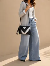 Sobre de cuero vacuno con textura croco en colores negro y plateado, con patrón en zigzag. Cuenta con una manija corta de mano, una correa larga ajustable y removible, y detalle de borla colgante.