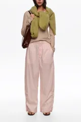 Pantalón jogger negro confeccionado en mezcla de lyocell y algodón, de tiro medio con bolsillos laterales y bajos ajustables mediante cordones elásticos con stoppers.