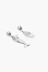 Par de aros metálicos plateados con cierre de gancho. Uno de los aros tiene forma de delfín y el otro tiene forma de mano.