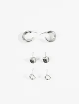 Set de tres pares de aros plateados con cierre de perno. Incluye un par de aros tipo argolla gruesa, un par con forma irregular y un par con diseño abstracto.