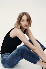 Jean tobillero de cinco bolsillos en denim de algodón, de tiro alto con piernas rectas y detalles de roturas sutiles.
