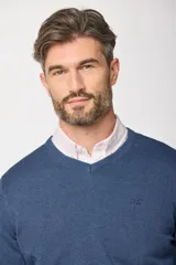 Suéter de tejido fino color azul marino, con cuello en V y manga larga. Presenta un pequeño logo bordado en el pecho.