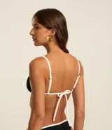 Top de bikini triangular negro con bies contrastante en color blanco y tirantes finos ajustables.