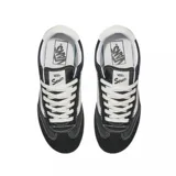 Championes Vans modelo Super Lowpro, de diseño urbano y perfil bajo. Presentan una combinación de gamuza negra en puntera y talón con paneles laterales de lona, destacando la icónica banda lateral Sidestripe en color blanco. Incluyen cordones blancos, suela de goma color caramelo y detalles de costuras visibles.