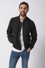 Campera bomber negra con cuello alto, cierre frontal y puños elásticos. Diseño minimalista y corte ajustado.