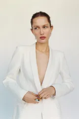 Blazer entallada color blanco, con cuello solapa combinado, manga larga con hombreras, bolsillos de plastrón en delantero, detalle de costuras marcadas, forro interior a tono y cierre frontal con botón forrado en mismo material.