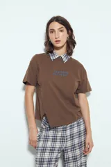 Remera de manga corta color marrón con cuello de camisa a cuadros azules y blancos. Presenta la frase "LIMITED EDITION" bordada en azul en el pecho y aberturas laterales en el dobladillo.