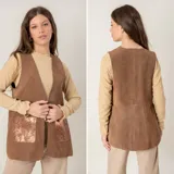 Chaleco de cuero gamuzado marrón, sin mangas, con escote en V y bolsillos frontales con detalle metalizado.