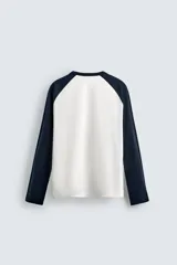 Camiseta de corte relajado con cuello redondo y mangas largas tipo raglán en contraste de color.