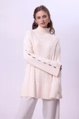 Sweater de punto color bordó con cuello alto y diseño de trenzas en el frente y las mangas. Presenta un corte holgado y largo, con puños y ruedo acanalados.