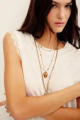 Musculosa blanca de lino con detalle de encaje en las sisas, cuello redondo y diseño sin mangas.