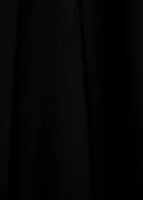 Vestido corto negro de corte recto con cuello alto y mangas asimétricas. Cuenta con cierre posterior de cremallera y botones.