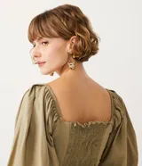 Blusa cropped de tricolina color beige, con escote corazón, detalle cruzado delantero y mangas 3/4 abullonadas. Posee lastex en la espalda para ajuste.