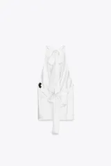 Top blanco de tejido satinado con cuello halter drapeado ajustable con lazada en el cuello y espalda descubierta con lazada.