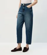 Pantalón de jean con corte new carrot, de cintura alta y estructura firme. Presenta un diseño holgado en la cadera que se estrecha hacia el bajo, con bolsillos funcionales y cierre frontal con botón y cremallera.