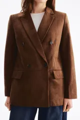 Blazer cruzado marrón con acabado cepillado, solapas de muesca, hombreras y bolsillos delanteros con solapa. Diseño con doble botonadura.