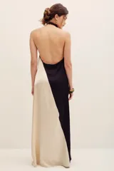Vestido largo halter confeccionado en poliéster, con diseño bicolor en negro y beige, escote cruzado y detalle bordado de girasol en el frente.