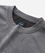 Remera oversized masculina de media malla con toque gamuza, color gris oscuro con efecto lavado. Presenta un bordado blanco en forma de media luna en el pecho y un estampado lettering en la parte delantera y trasera.