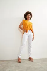 Pantalón de corte slim en color blanco, confeccionado en denim, con cierre frontal de botón y cremallera, y bolsillos laterales.