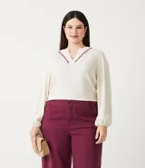 Blusa amplia color crema en viscosa con escote V con detalle de bordado en el escote, manga larga y elástico en el puño.