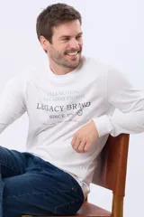 Remera de algodón de manga larga color azul marino, con cuello redondo y estampado frontal en tonos celestes y dorados que dice "Celebrating All Good Things Legacy Brand Since 1972" y "Live a life that you would relive".