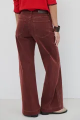 Jean de corte wide leg en color bordó, con costuras a contratono y diseño de cinco bolsillos.