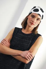 Vestido corto sin mangas, de tejido de punto en color azul marino con efecto jaspeado o tweed en tonos claros. Presenta un corte amplio y relajado, con cuello redondo y bordes en contraste.