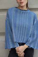 Sweater tejido de punto a rayas horizontales negras y plateadas, con cuello alto, mangas tres cuartos y calce oversize.