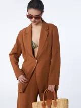 Blazer sastrero color marrón, con botonadura simple, solapas delanteras y bolsillos plaqué no funcionales.