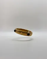 Pulsera estilo vintage de acero dorado, con diseño de eslabones estriados y apliques de piedras naturales oscuras.