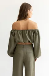 Blusa corta color salmón, con escote recto con elástico, mangas largas abullonadas con elástico en los puños y corte crop.