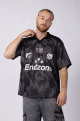 Camiseta de estilo futbolero con cuello polo, manga corta y corte relajado. Presenta un estampado abstracto en tonos grises y negros, con el número 15, el logo de la marca y la palabra Endzone en el frente.